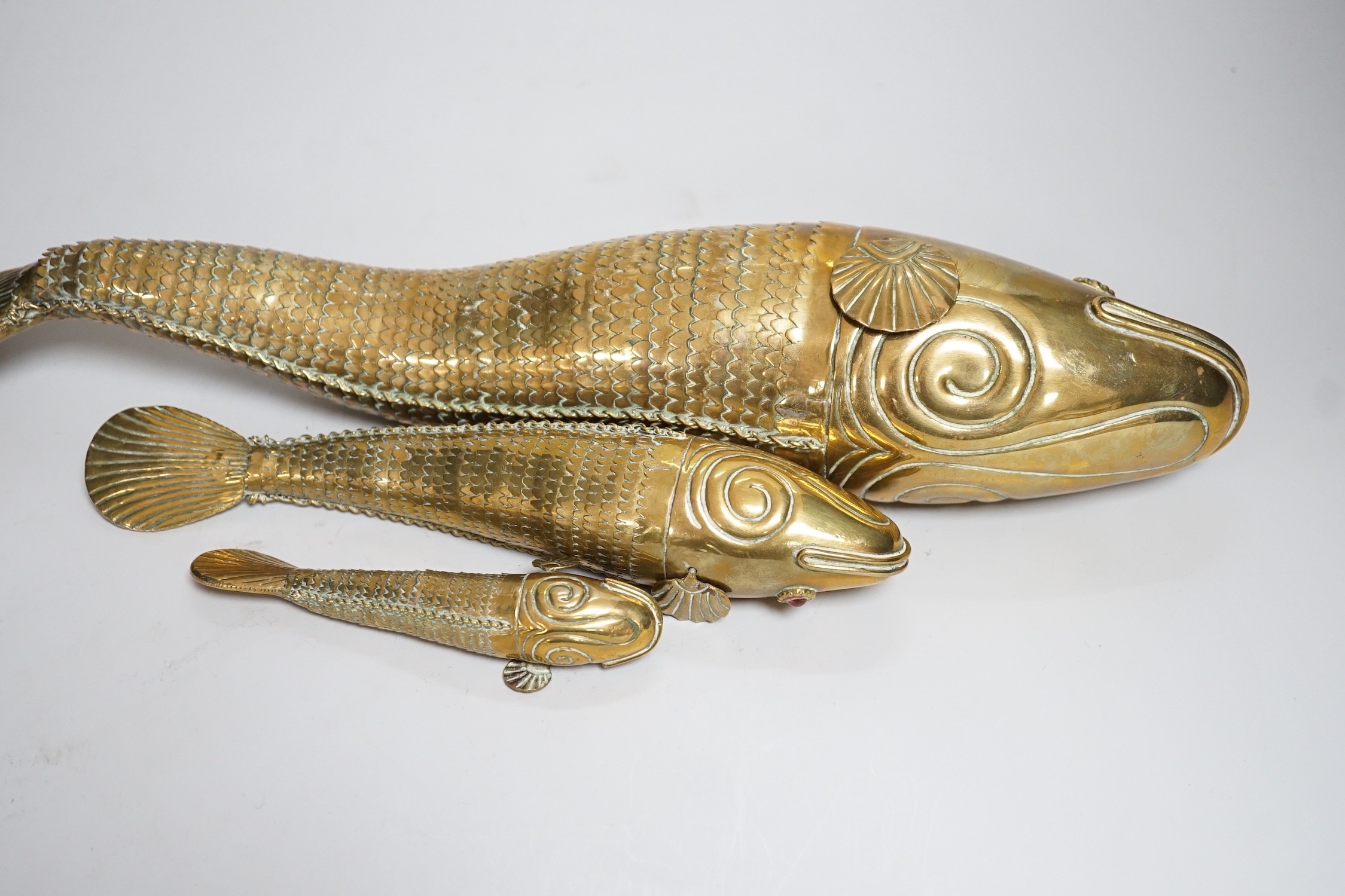 A set of three graduated brass articulated fish, largest 43.3cms long